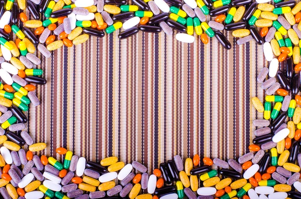 Pills, drugs, supplements on striped cloth, healthy lifestyle.