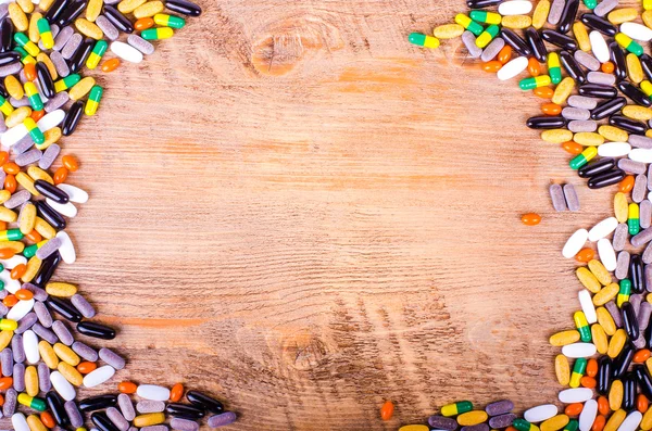 Pills, drugs, supplements on wooden background, healthy