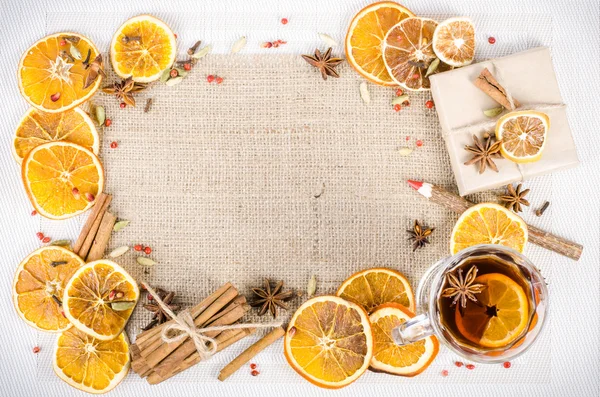 Dried oranges, cinnamon, cloves, cardamom, handmade milk chocolate with nuts, mulled wine, wooden pencil on sackcloth, canvas. Christmas, New Year and winter. Free space for your text.