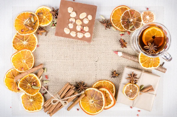 Dried oranges, cinnamon, cloves, cardamom, handmade milk chocolate with nuts, mulled wine, wooden pencil on sackcloth, canvas. Christmas, New Year and winter. Free space for your text.