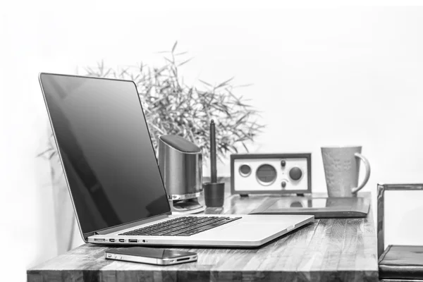 Laptop on wooden desk black and white color