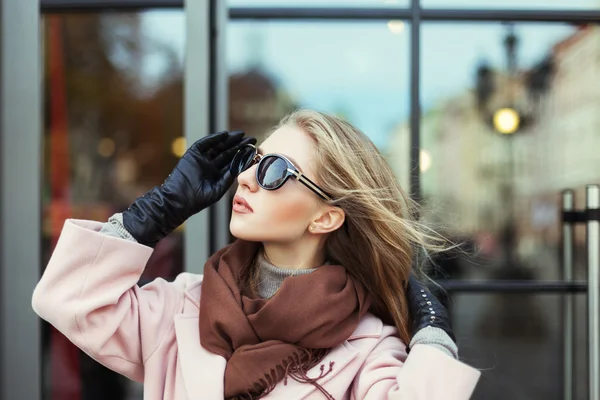 Portrait of beautiful young woman with sunglasses. Model looking aside. City lifestyle. Female fashion. Closeup. Reflection background