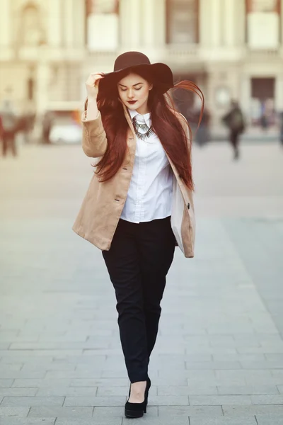 Full body portrait of young beautiful lady wearing stylish classic clothes walking at street. Girl looking down. Plus size model. Female fashion concept. Toned