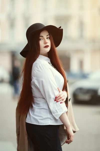 Portrait of young beautiful lady wearing stylish classic clothes posing on the street. Girl looking at camera. Plus size model. Female fashion concept. Close up. Toned