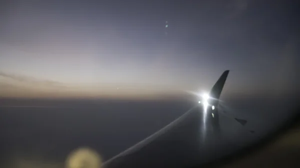 The view of airplane wing and horizon sky at dawn