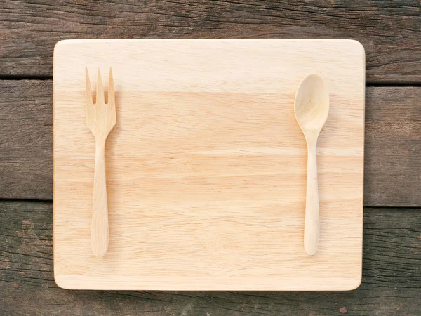The wooden spoon with fork and wooden board