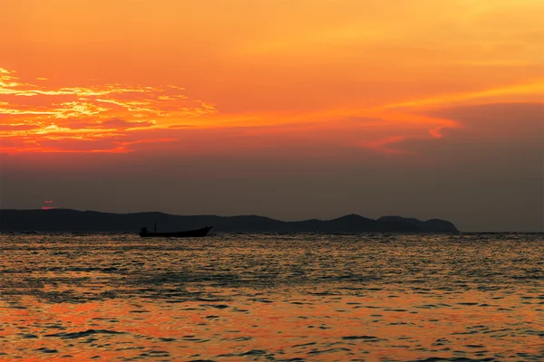 Cloudy sunset with silhouette of lonely boat