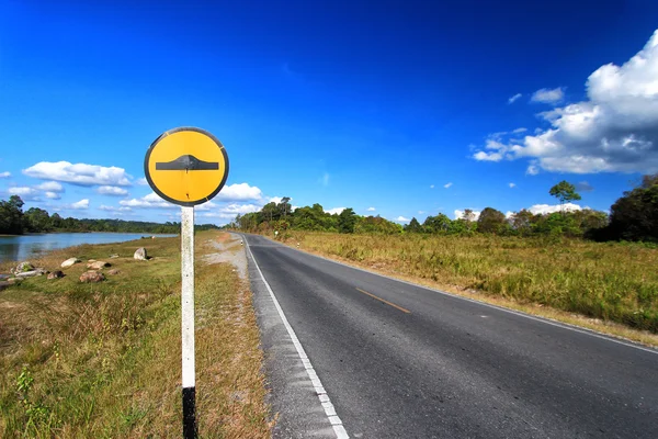 Speed bump sign beside asphalt road.