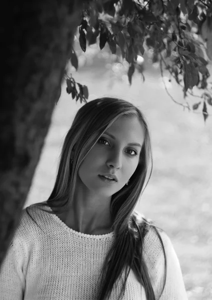 Young woman standing near tree. black and white portrait