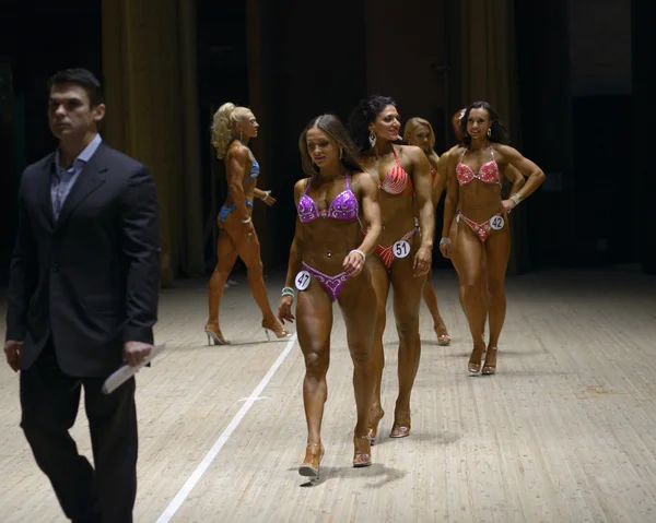 Female fitness athletes leaving podium. Ukraine bodybuilding and fitness cup. Kiev, 23 May 2015