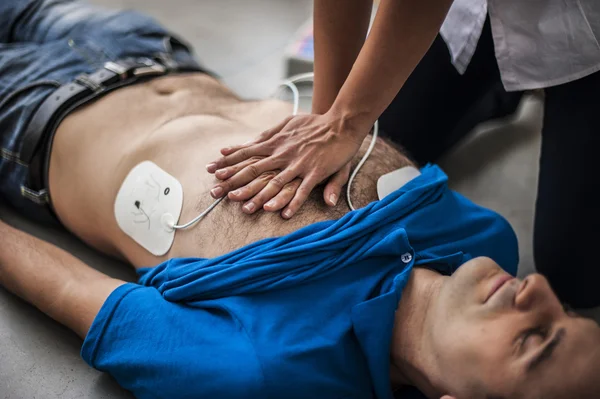 Rescuer making cardiopulmonary resuscitation to an unconscious man