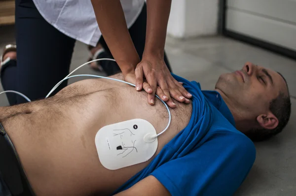Rescuer making cardiopulmonary resuscitation to an unconscious man
