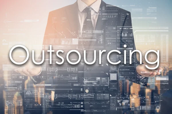 Businessman is presenting text: Outsourcing