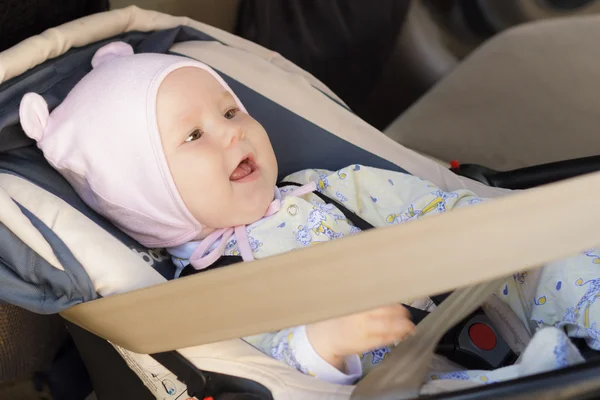 Little newborn baby girl rests in the car seat