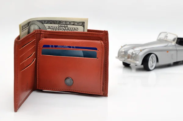 Wallet with US Dollars and blured old toy car background