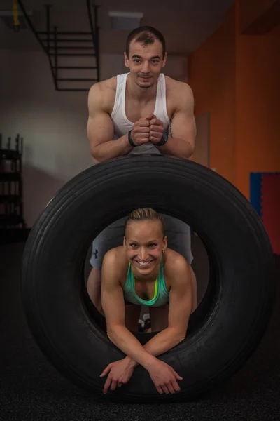 Fitness - a young couple in love practicing in the small gym