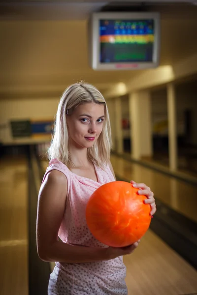 Young lady at the bowling alley with the ball in hand, getting r