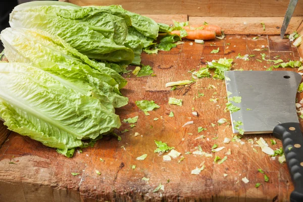 Cleaver vegetables on a wooden board set to meet the lettuce