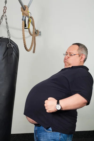 Fat man match belly with a punching bag