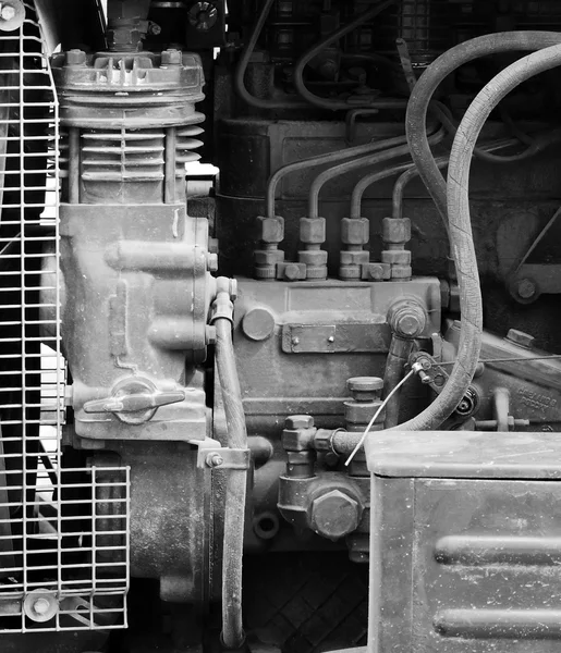 Hoses, engine and spare parts inside the hood of the tractor