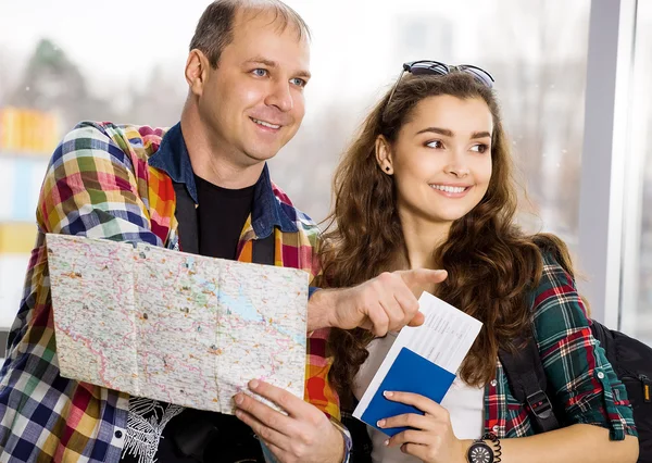 Young man and woman. Keep a map and shows the direction. Europeans. Gathered in a guided tour. Close-up. Honeymoon