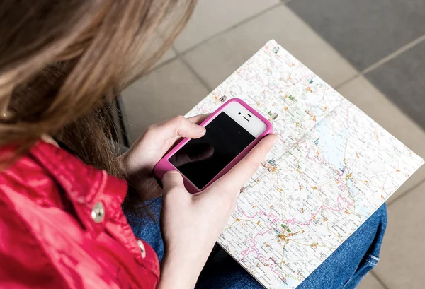 Woman looking at the map and telephone number. She is studying the route. Close-up