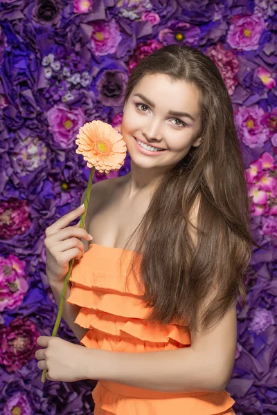 Beautiful Spa model Girl with Perfect Fresh Clean Skin. woman  holding a flower gerber . Youth and Skin Care Concept.