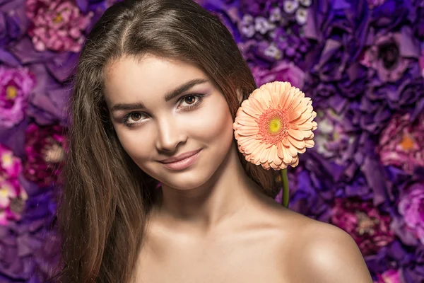 Beautiful Spa model Girl with Perfect Fresh Clean Skin. woman  with a flower gerber. Youth and Skin Care Concept.