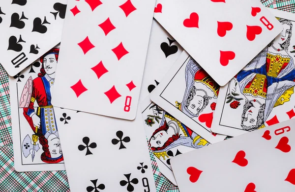Some playing cards lays on a background of playing cards