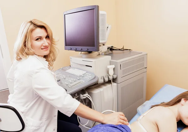 The man checked on the kidneys by ultrasound device in the hospital.doctor examines a young woman with ultrasound