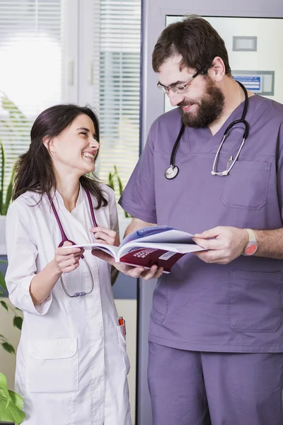 Girl Doctor in a white coat with a stethoscope and male doctor with book