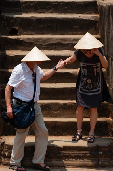 Two persons with hat climbing down stairs