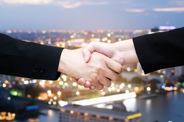 Business people handshaking in blurred bokeh background