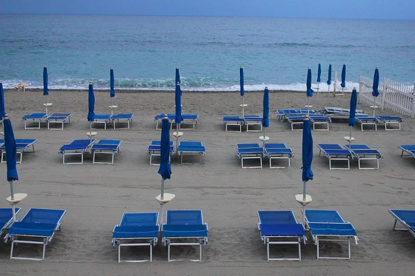 Deck chairs and umbrellas in front of the sea
