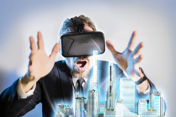 The man  dressed in glasses virtual reality model looks at the skyscrapers of the modern city of the future in 3D