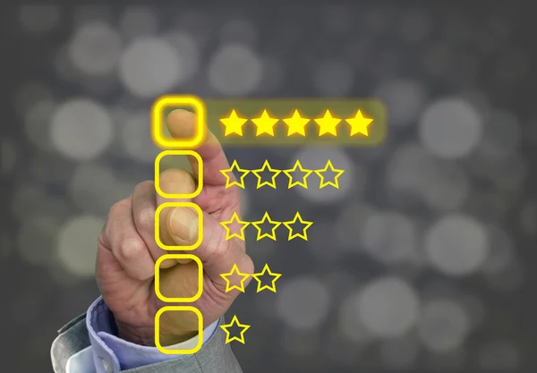 Hand pressing yellow five star button of performance rating