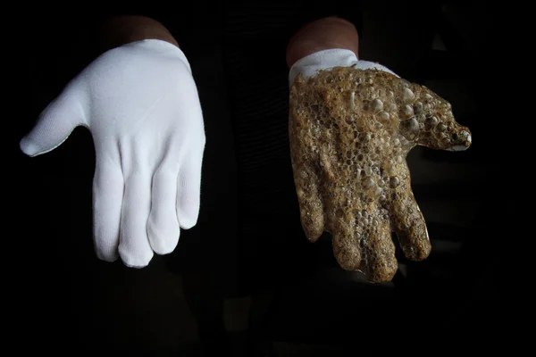 Clean and dirty glove. dirty foam after washing the grain