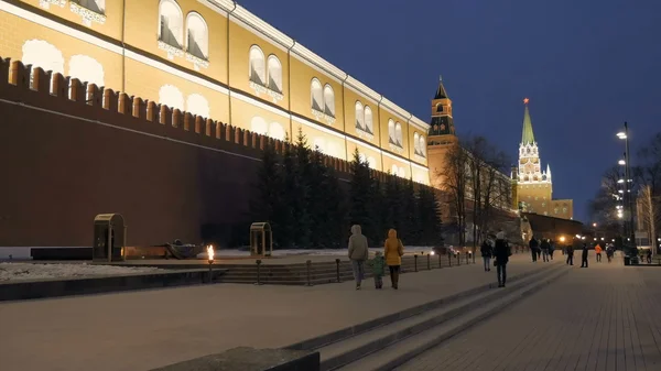 Family is going to eternal flame near a wall of Moscow Kremlin in evening