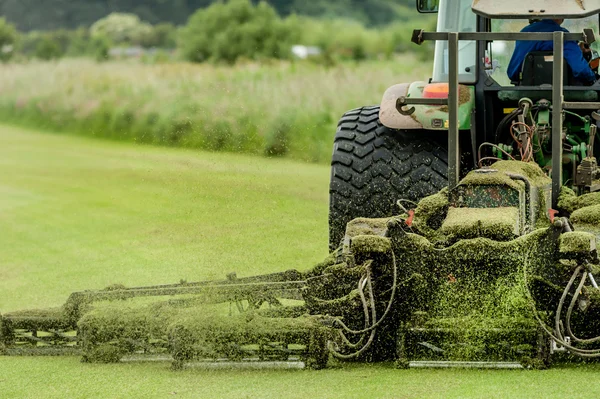 A tractor being used to cut grass