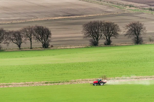 An agricultural tractor during a fertilizer