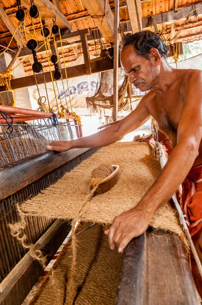 Man working with hand  operated coir loom
