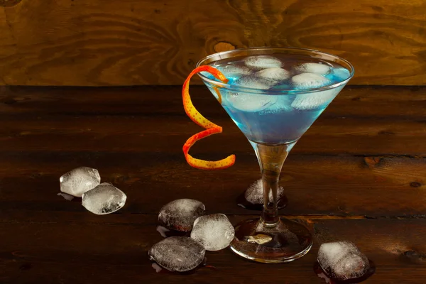 Blue Martini cocktail on the dark wooden background