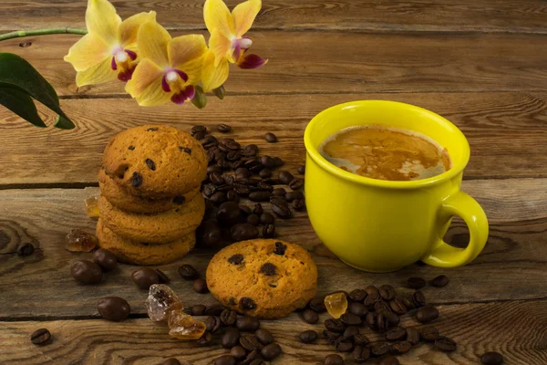 Coffee cup, cookies and yellow  orchid