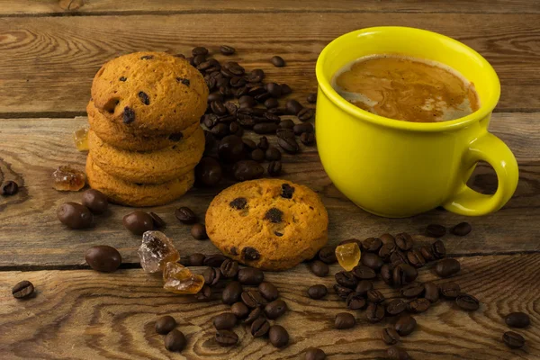 Yellow cup of strong coffee and cookies