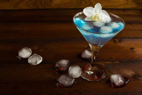 Blue margarita cocktail and white orchid
