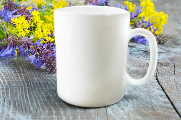 White coffee mug mockup with lilac and yellow flowers