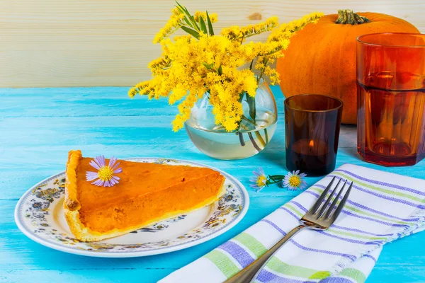 Thanksgiving pumpkin pie slice on the blue wooden table