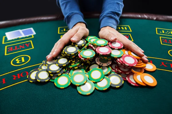 Poker player going all-in pushing his chips forward