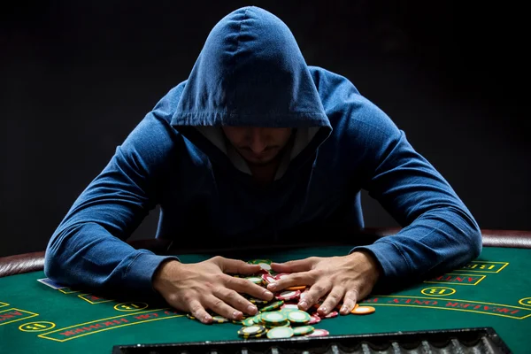 Poker player taking poker chips after winning