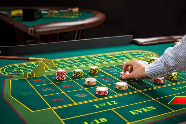 Picture of a green table and betting with chips.